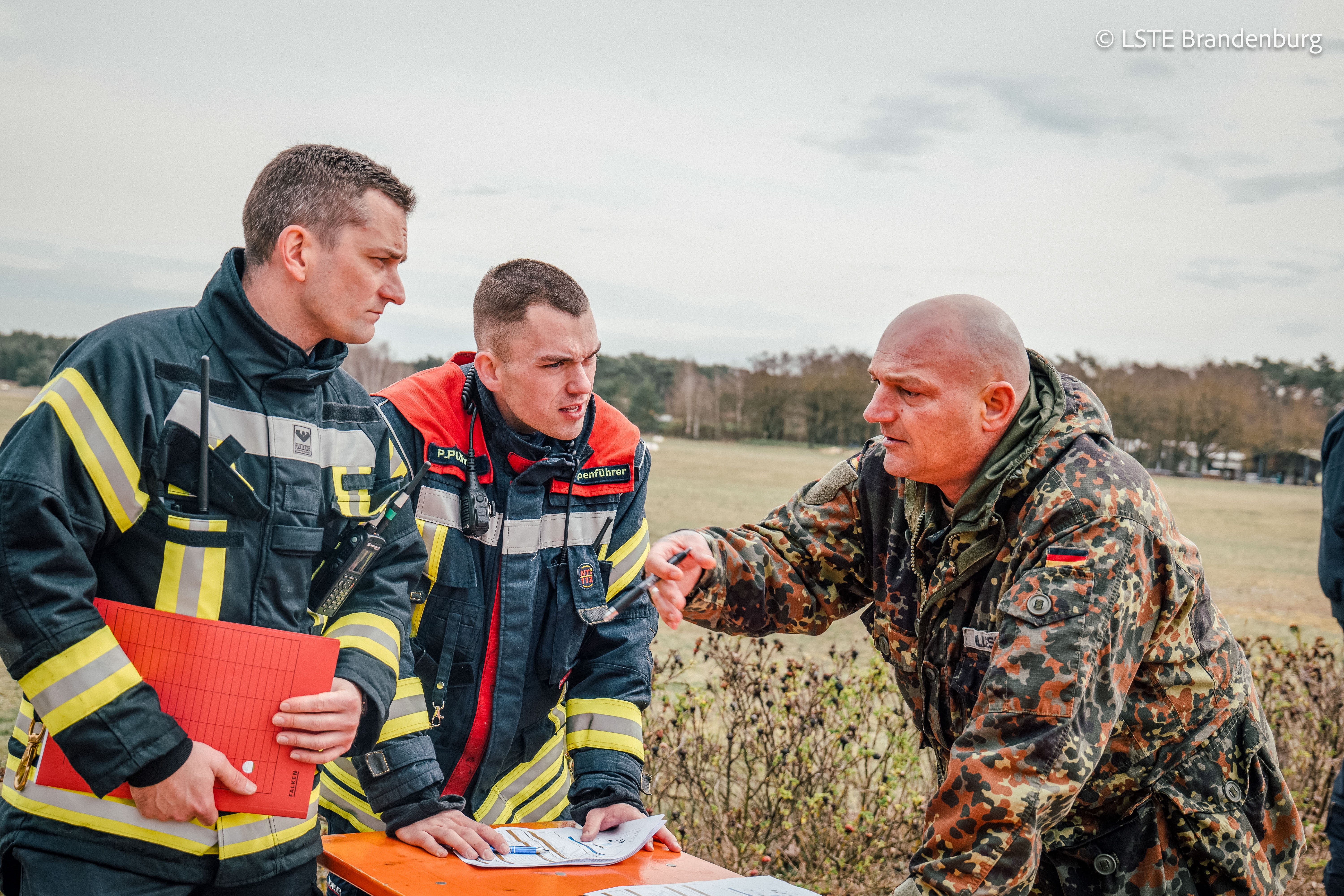 Akteure der LSTE, der öffentlichen Feuerwehren und der Bundeswehr führen ein fachliches Gespräch 